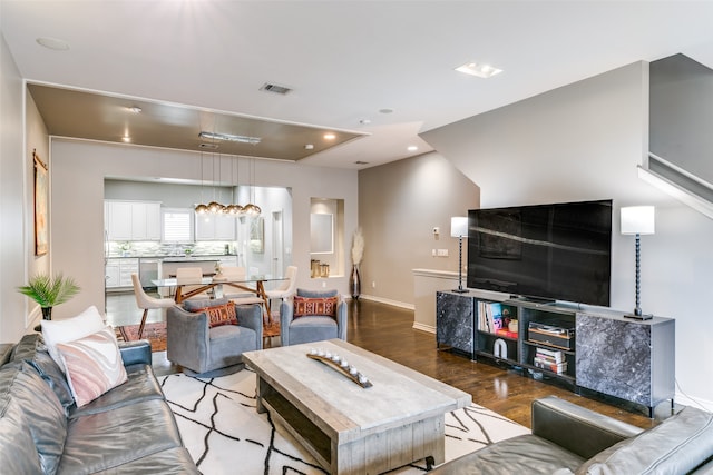 living room with hardwood / wood-style flooring and a notable chandelier