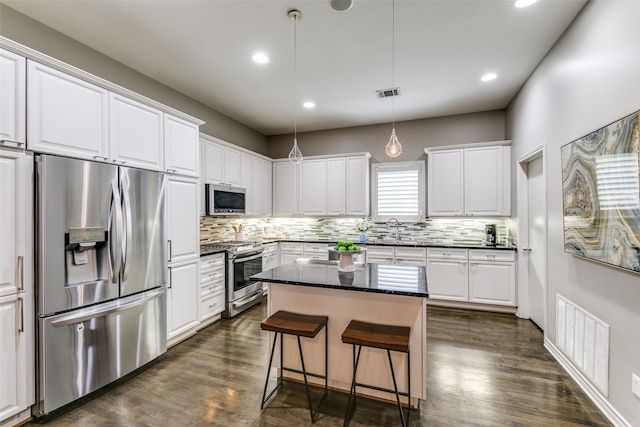 kitchen featuring pendant lighting, a kitchen island, sink, appliances with stainless steel finishes, and white cabinetry