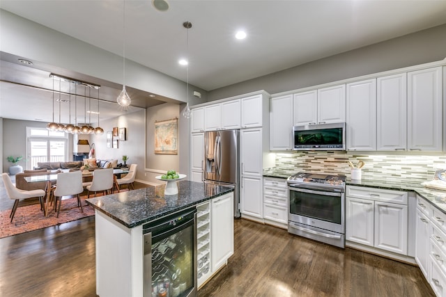 kitchen featuring stainless steel appliances, dark stone countertops, beverage cooler, dark hardwood / wood-style flooring, and white cabinetry