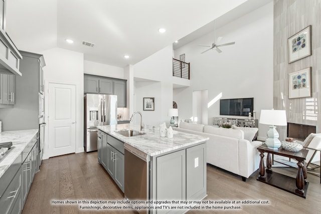 kitchen with a center island with sink, gray cabinetry, and appliances with stainless steel finishes