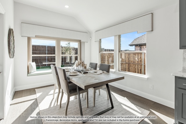 dining room featuring vaulted ceiling and light wood-type flooring