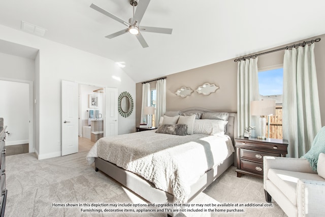 bedroom with ceiling fan, light colored carpet, connected bathroom, and vaulted ceiling