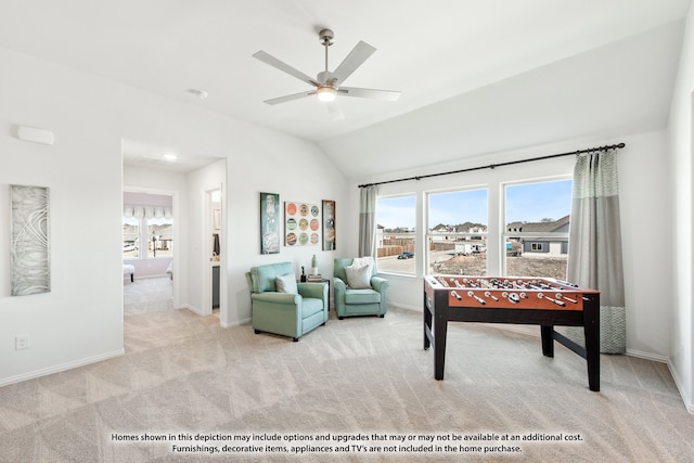 interior space with ceiling fan, vaulted ceiling, a wealth of natural light, and light carpet