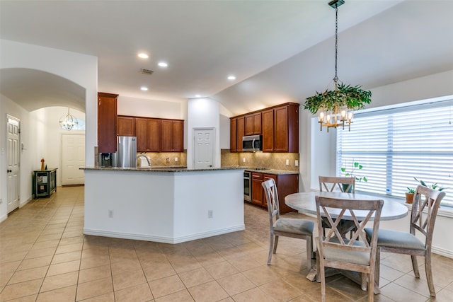 kitchen with lofted ceiling, light tile patterned floors, decorative light fixtures, backsplash, and stainless steel appliances