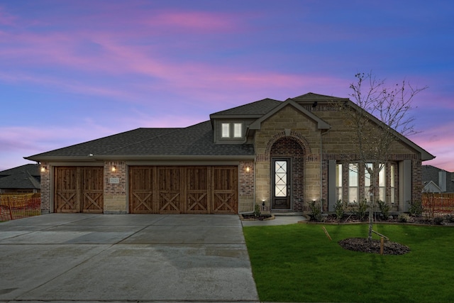 view of front facade featuring a garage and a lawn