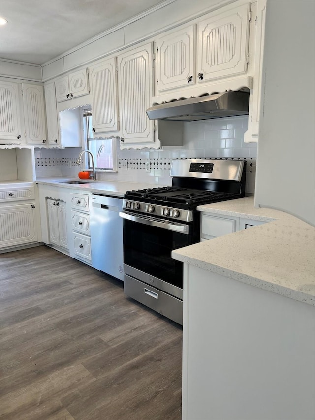 kitchen with sink, stainless steel appliances, tasteful backsplash, dark hardwood / wood-style flooring, and white cabinets