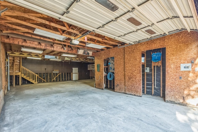 garage featuring white fridge and a garage door opener