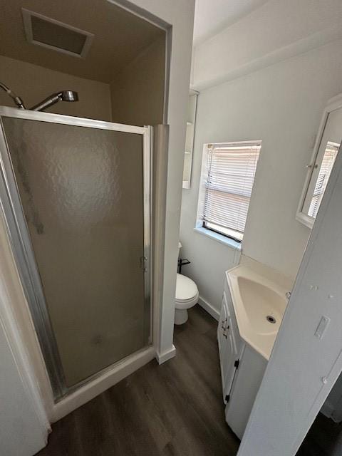 bathroom with vanity, hardwood / wood-style flooring, toilet, and an enclosed shower