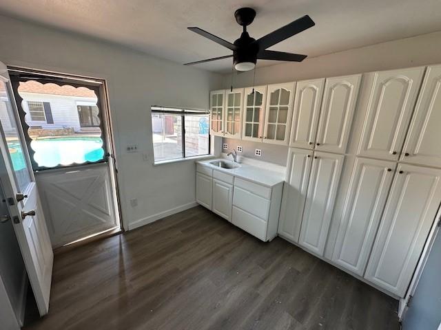 kitchen featuring dark hardwood / wood-style flooring, white cabinetry, ceiling fan, and sink