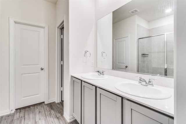 bathroom with walk in shower, vanity, and hardwood / wood-style flooring