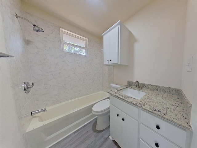 full bathroom with hardwood / wood-style flooring, vanity, toilet, and tiled shower / bath