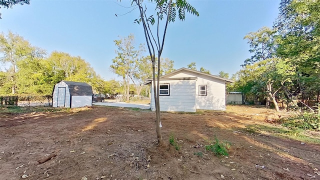 view of side of property featuring a storage shed