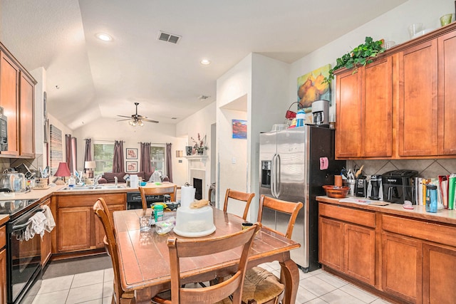 kitchen featuring lofted ceiling, black appliances, ceiling fan, light tile patterned floors, and tasteful backsplash