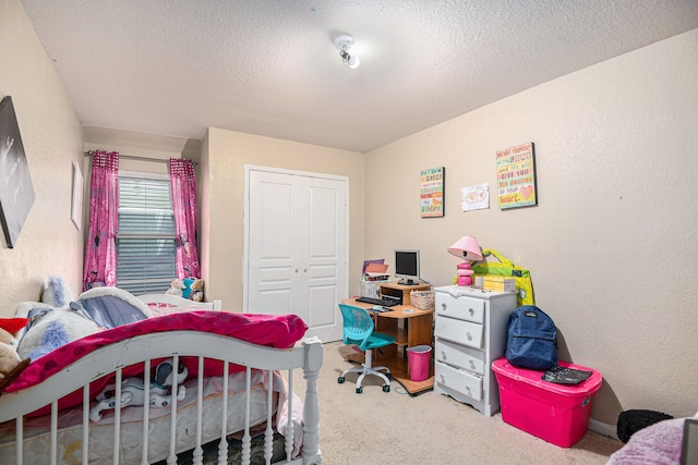 bedroom with a textured ceiling, carpet floors, and a closet