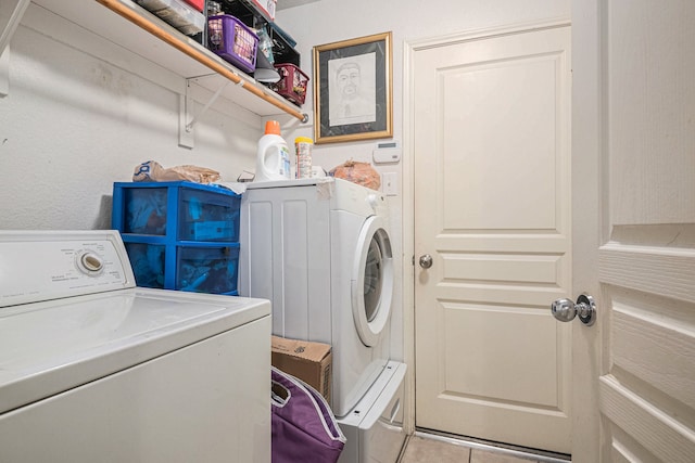 laundry area featuring washer and clothes dryer and light tile patterned floors