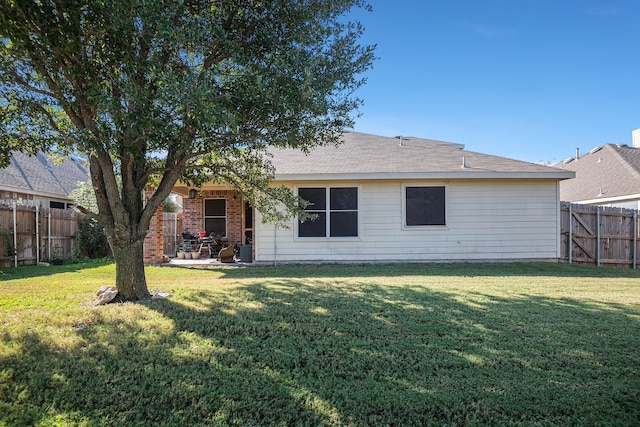 rear view of house with a patio area and a yard