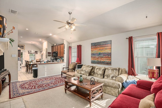 living room with light tile patterned floors, lofted ceiling, and ceiling fan with notable chandelier