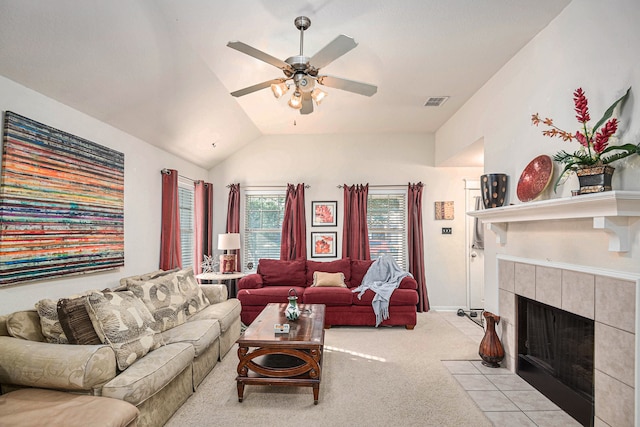 living room with light carpet, lofted ceiling, a tiled fireplace, and ceiling fan