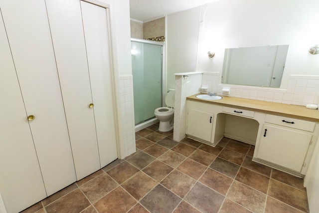 bathroom featuring vanity, a textured ceiling, backsplash, a shower with shower door, and toilet