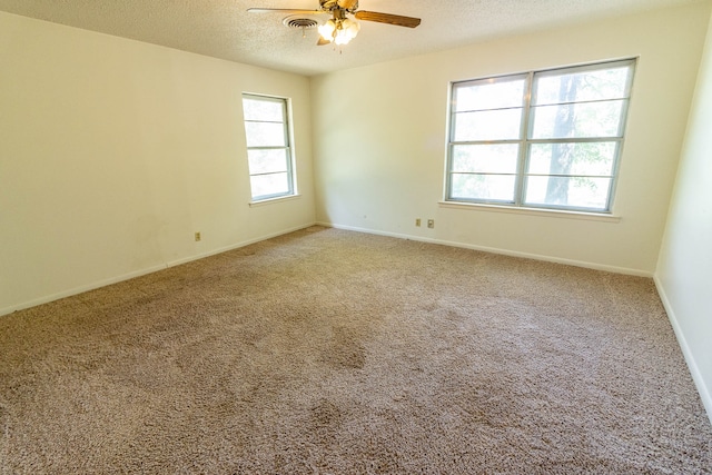 unfurnished room with ceiling fan, a textured ceiling, and carpet