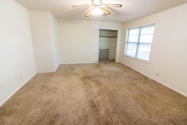 unfurnished bedroom with carpet, a textured ceiling, and ceiling fan