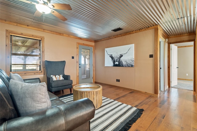 living room featuring light hardwood / wood-style flooring, ceiling fan, and ornamental molding