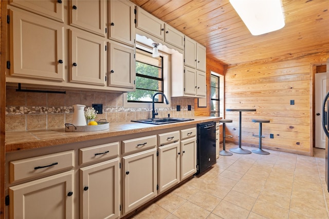 kitchen featuring sink, dishwasher, wooden walls, light tile patterned flooring, and wood ceiling