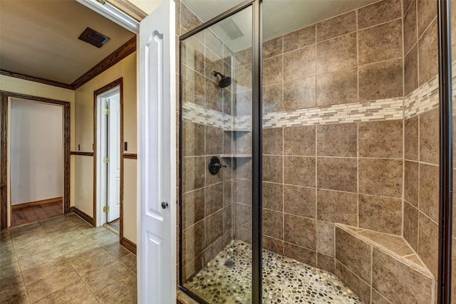 bathroom with a shower with door and ornamental molding