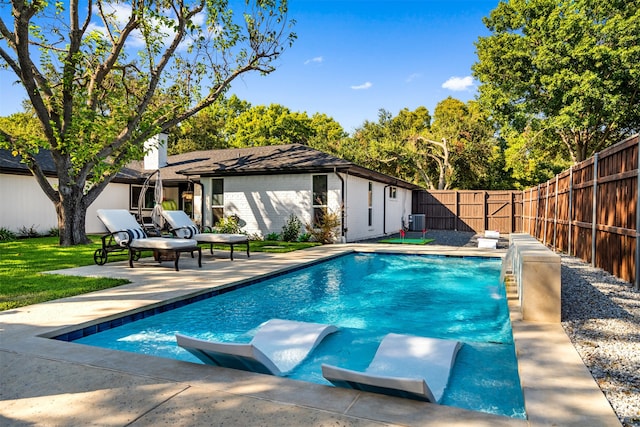 view of swimming pool featuring a patio and central air condition unit