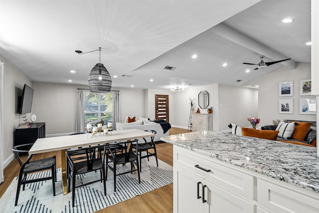 kitchen featuring light wood-type flooring, ceiling fan with notable chandelier, decorative light fixtures, light stone countertops, and white cabinets