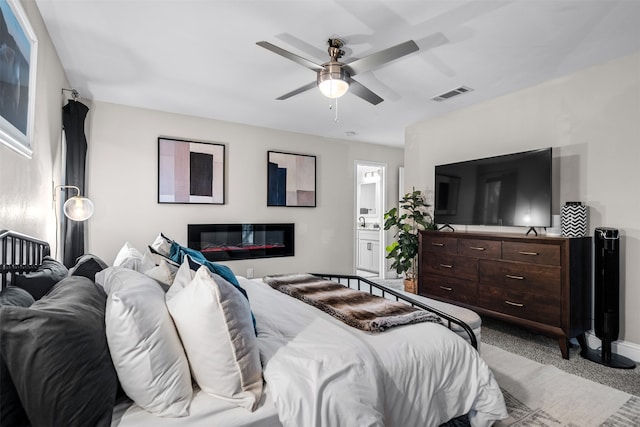 bedroom with light carpet, connected bathroom, and ceiling fan