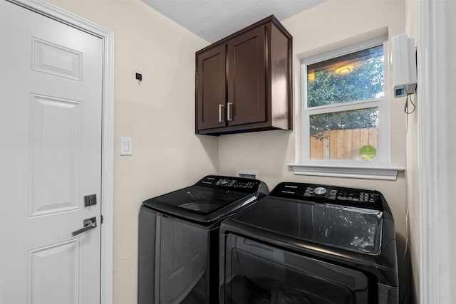 laundry area with washer and clothes dryer and cabinets