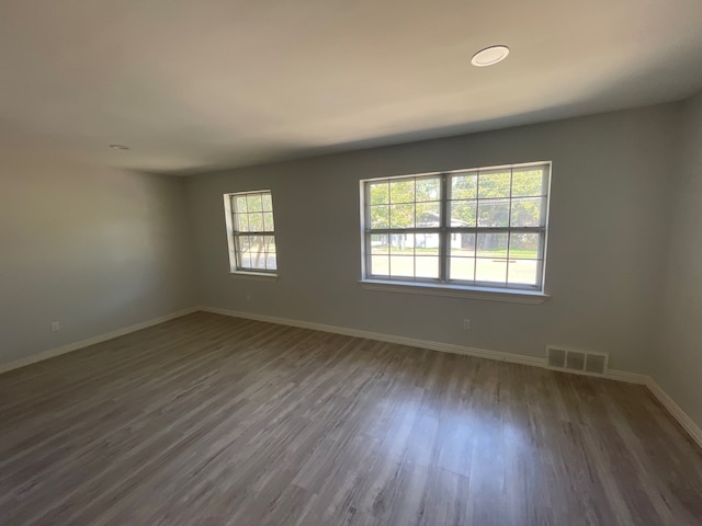 unfurnished room with dark wood-type flooring