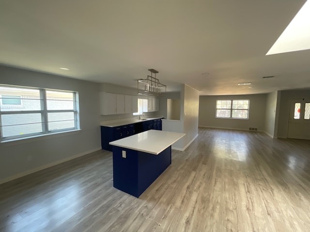 kitchen with hardwood / wood-style floors, pendant lighting, white cabinetry, and a center island