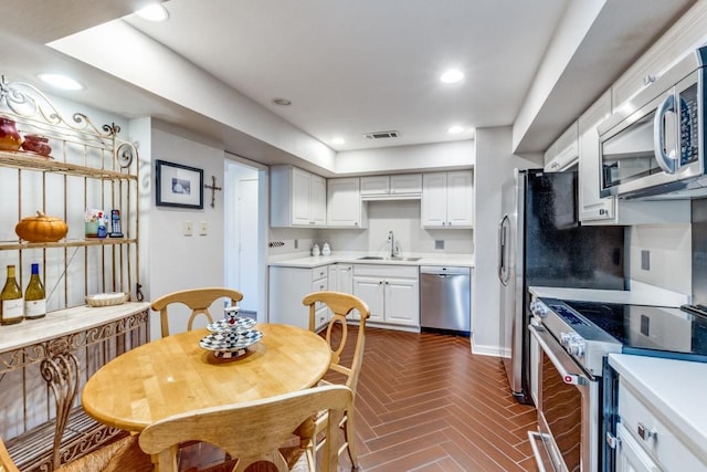 kitchen featuring a sink, light countertops, white cabinets, appliances with stainless steel finishes, and visible vents