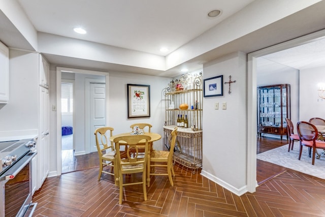 dining space featuring dark parquet flooring