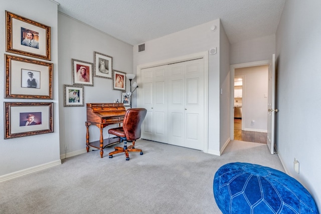 office area featuring light carpet and a textured ceiling