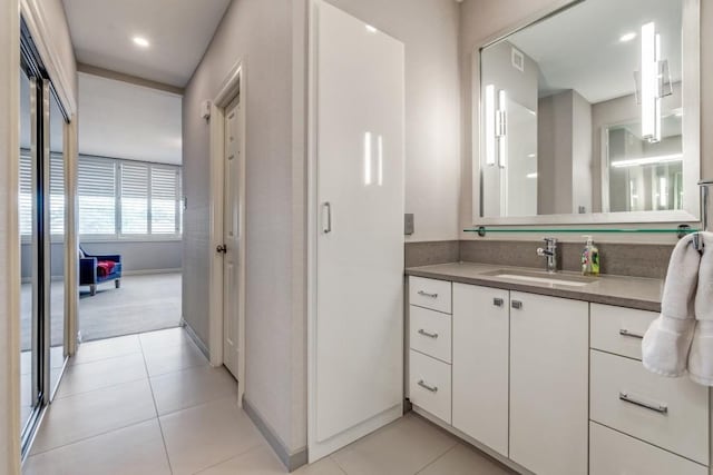 bathroom with tile patterned flooring, baseboards, vanity, and visible vents