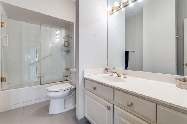 bathroom with vanity, tile patterned flooring, bath / shower combo with glass door, and toilet