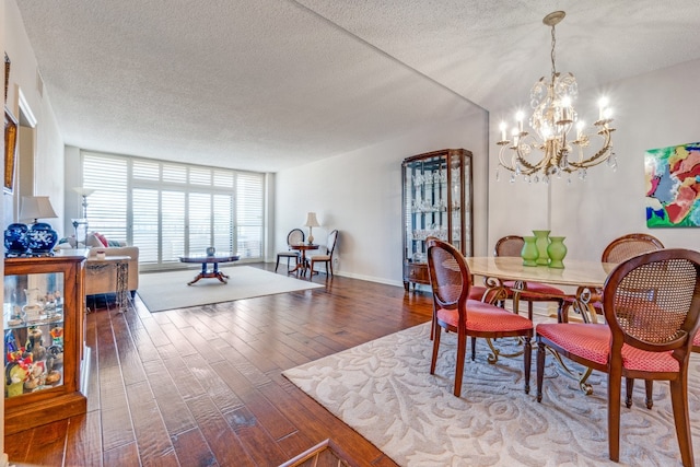 dining room with a wall of windows, hardwood / wood-style floors, a chandelier, and a textured ceiling