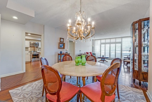 dining room with baseboards, a chandelier, a textured ceiling, and recessed lighting