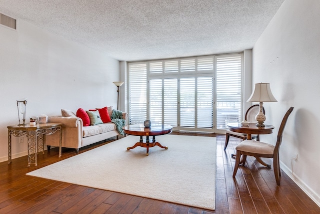 living room with expansive windows, dark hardwood / wood-style floors, and a textured ceiling