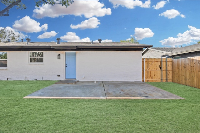 rear view of property featuring a yard and a patio