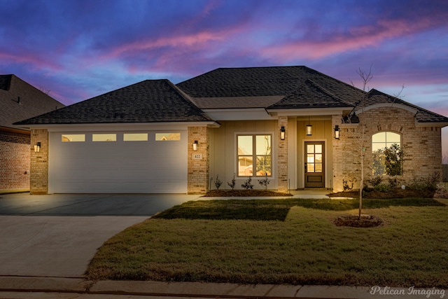 view of front of home with a yard and a garage