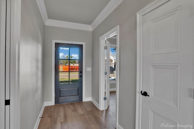 entryway with light hardwood / wood-style floors and crown molding