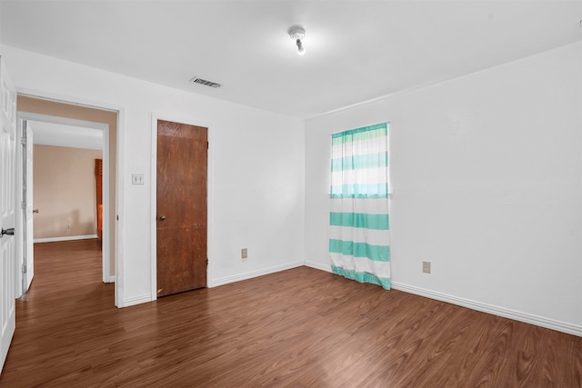 unfurnished room with dark wood-type flooring