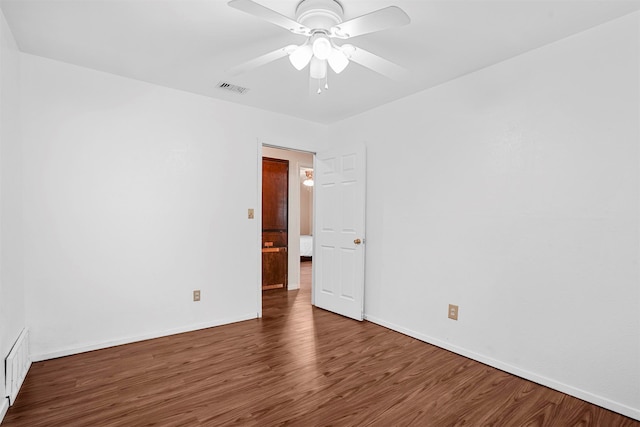 empty room with ceiling fan and dark wood-type flooring