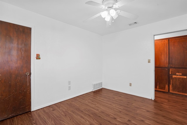 unfurnished room with ceiling fan and dark hardwood / wood-style flooring