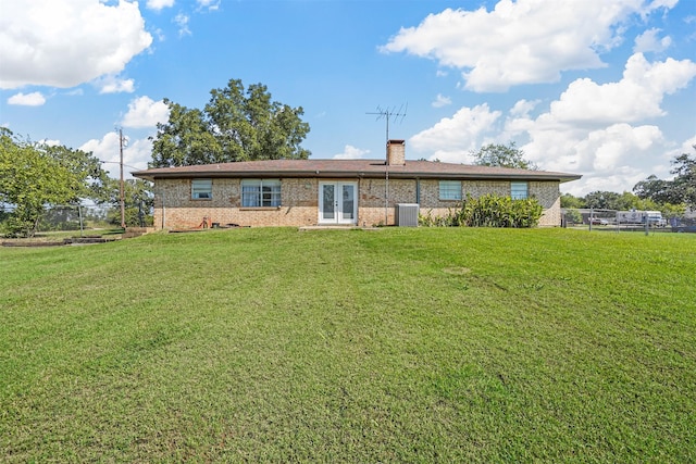 rear view of house with french doors, a yard, and cooling unit