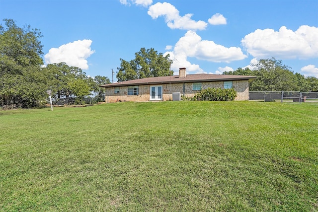 rear view of house featuring a lawn